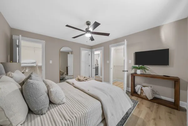 a bedroom with a bed and a flat tv screen on wall