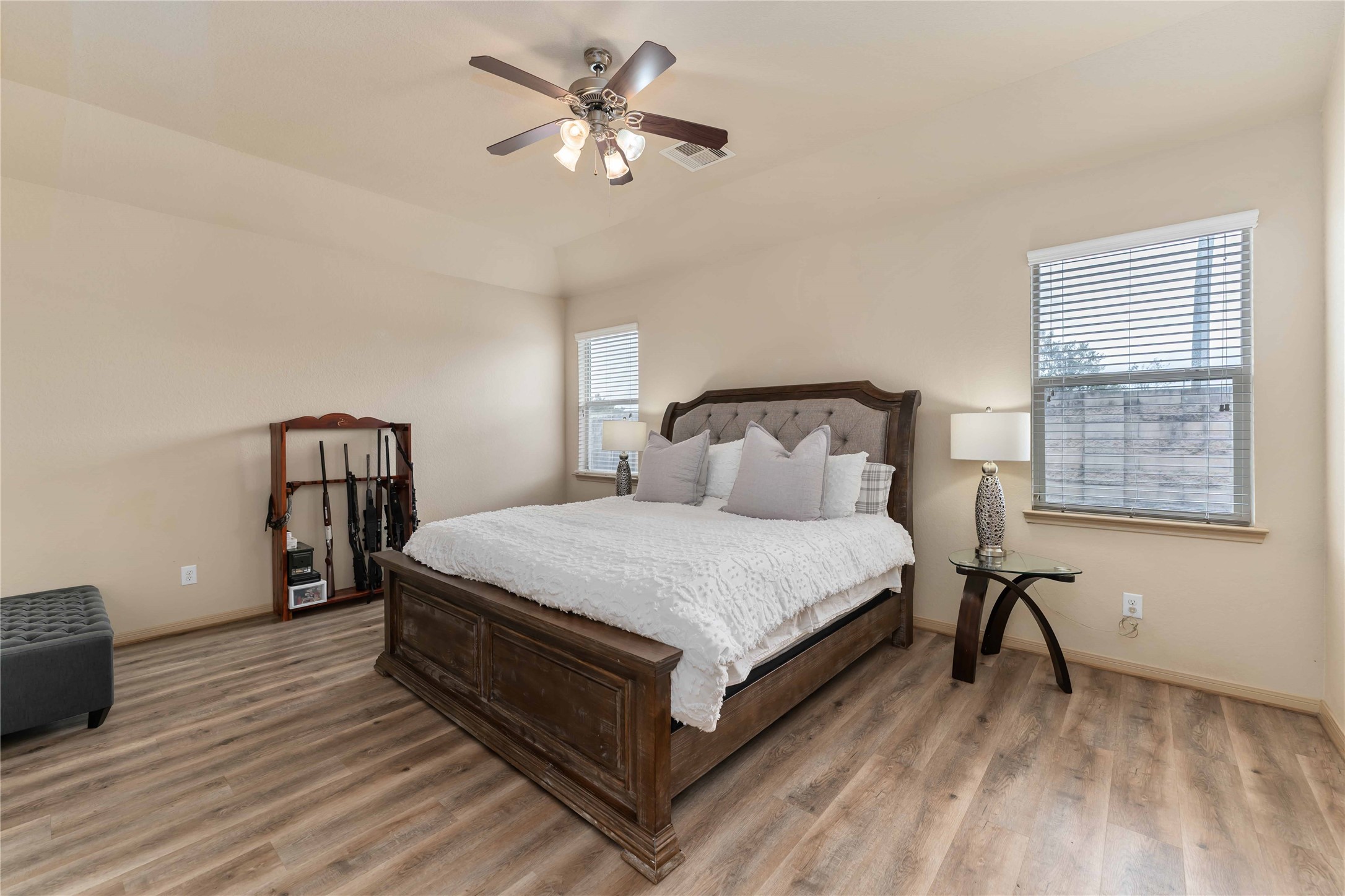 2502 Tiger Eye Drive Rosharon, TX 77583 - Photo 12 of 29 This spacious bedroom features a wo windows for natural light, a ceiling fan, and wood flooring. There's ample space for additional furniture.
