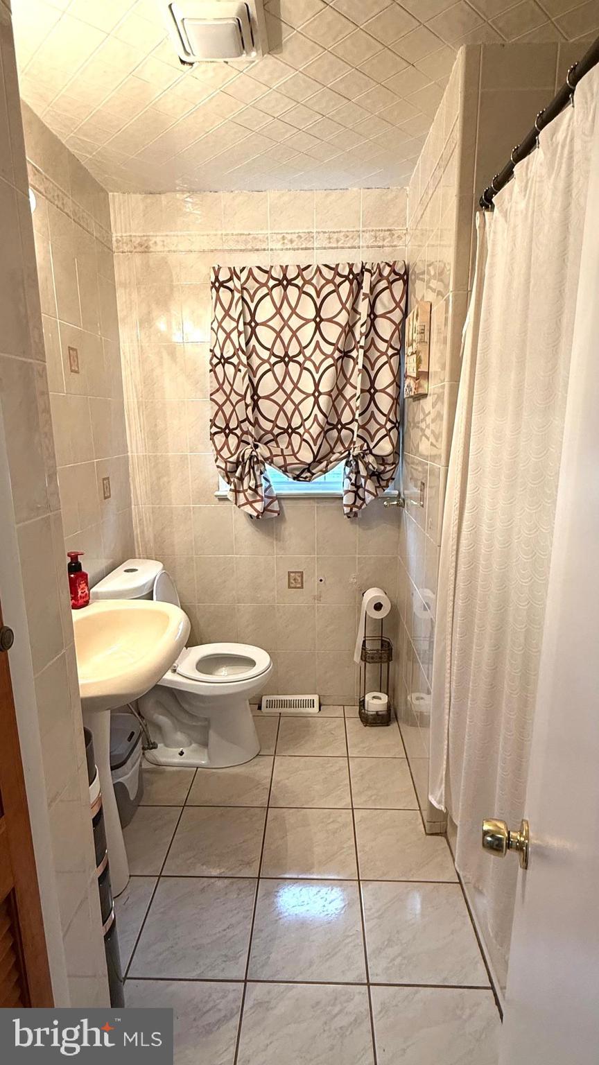 654 Buckshutem Road Bridgeton, NJ 08302 - Photo 7 of 14 a bathroom with a toilet a sink and a mirror