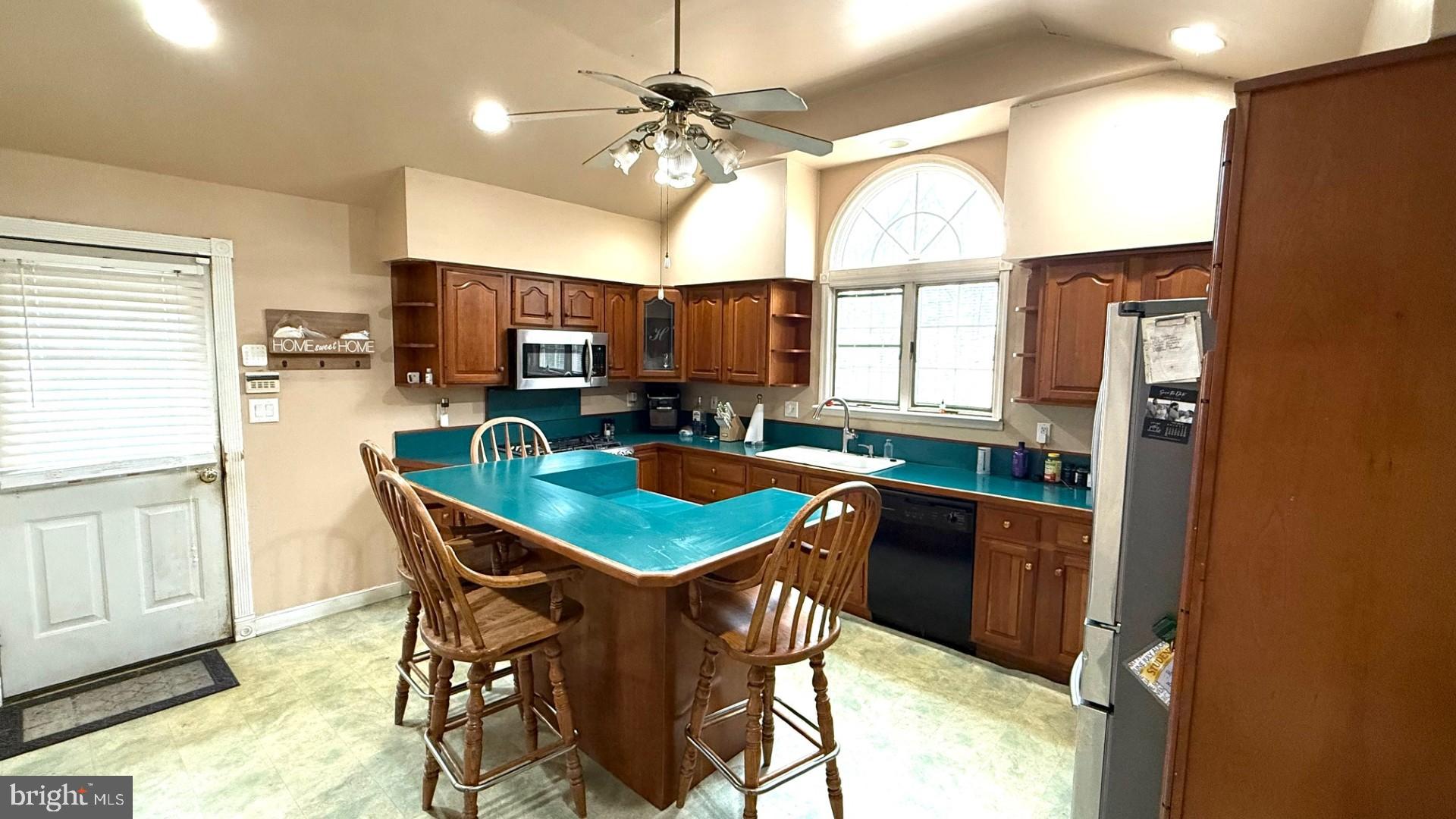 654 Buckshutem Road Bridgeton, NJ 08302 - Photo 9 of 14 a kitchen with a table chairs refrigerator and cabinets