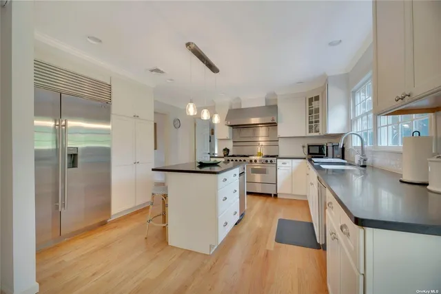 a kitchen with stainless steel appliances granite countertop a sink a stove and a refrigerator