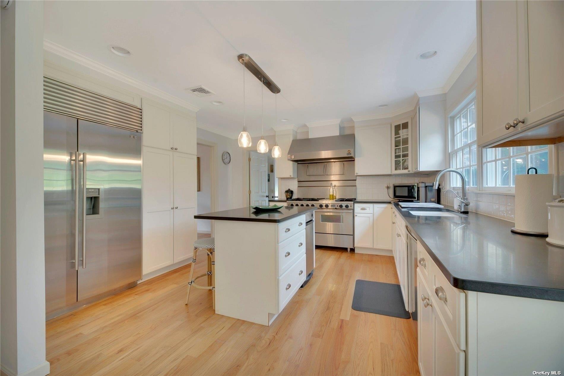 1460 Hillcrest Drive Orient, NY 11957 - Photo 15 of 37 a kitchen with stainless steel appliances granite countertop a sink a stove and a refrigerator
