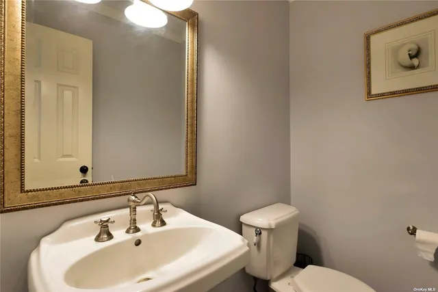 a bathroom with a sink mirror and toilet