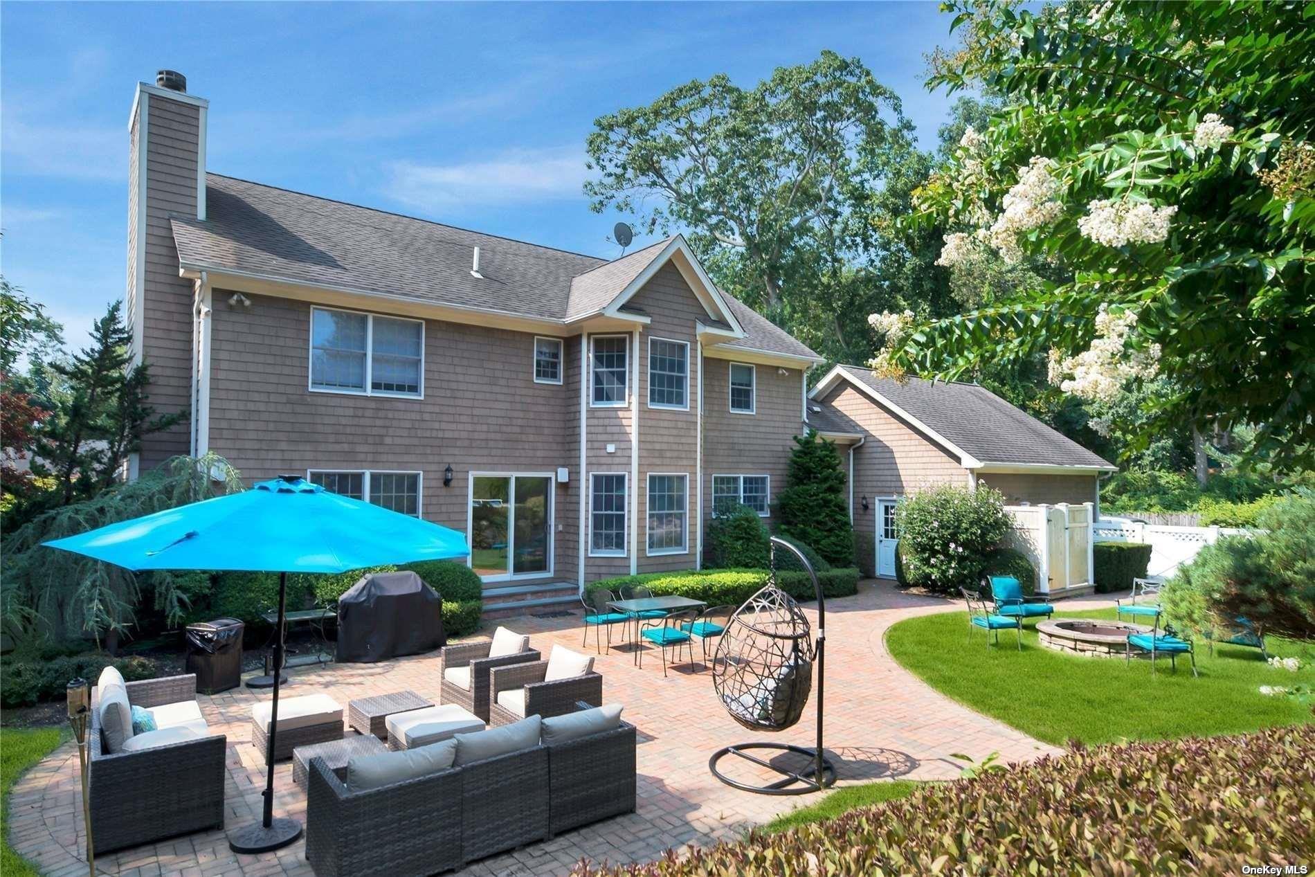 1460 Hillcrest Drive Orient, NY 11957 - Photo 2 of 37 a patio with a table and chairs under an umbrella