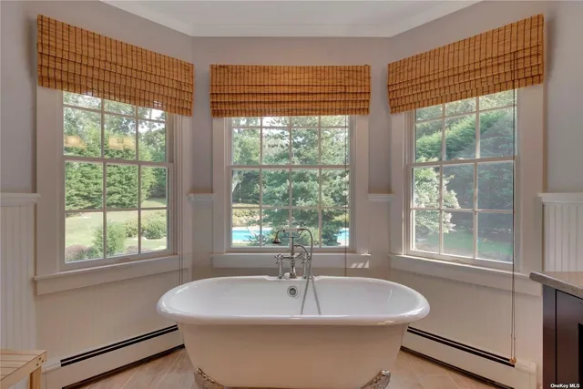 a white bath tub sitting in a bathroom next to a window