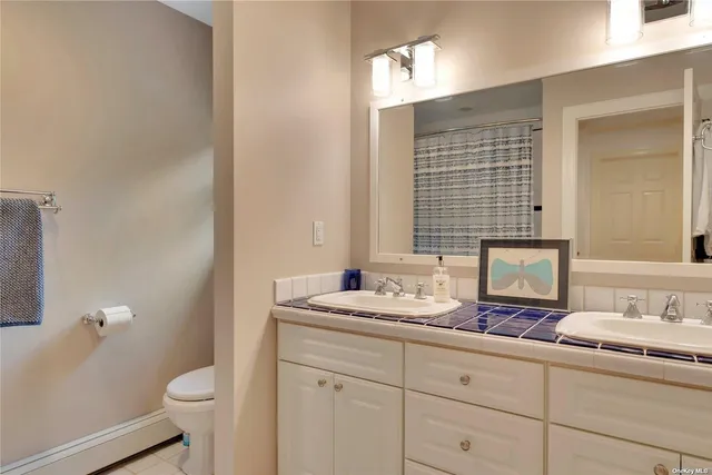 a bathroom with a granite countertop sink toilet and mirror
