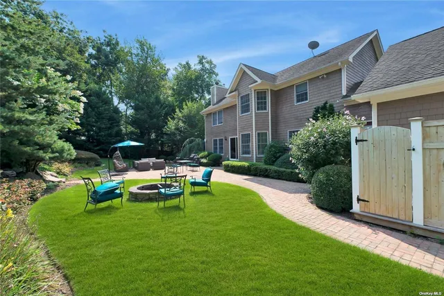 a view of a house with backyard sitting area and garden