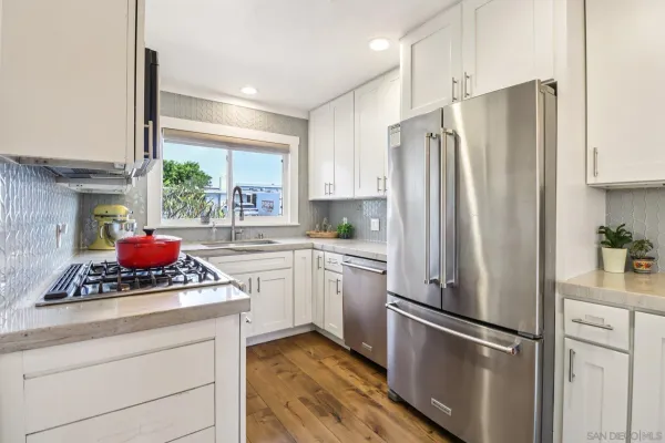 a kitchen with stainless steel appliances a refrigerator sink and cabinets