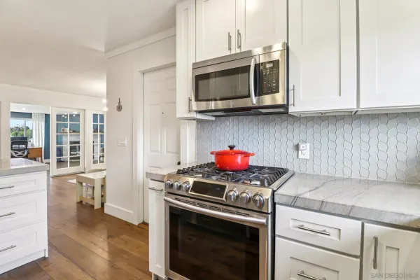 a kitchen with stainless steel appliances granite countertop a stove microwave and cabinets