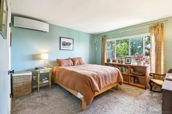 a bedroom with a bed and a large window