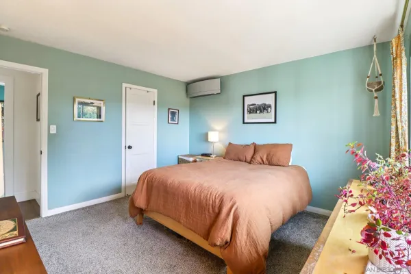 a bedroom with a bed and a painting on the wall