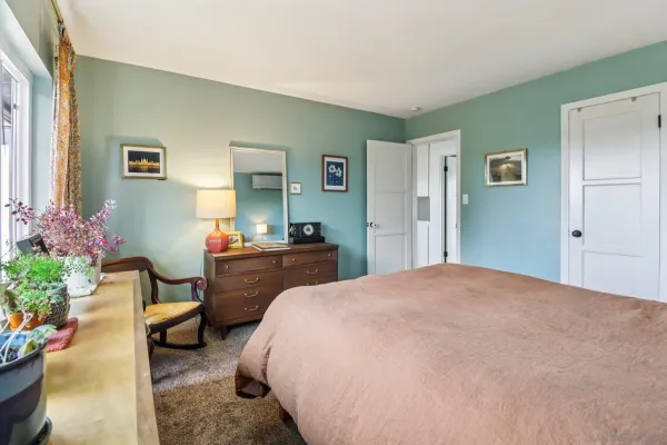 a bedroom with a bed and a table chair
