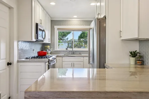 a kitchen with stainless steel appliances granite countertop a stove a sink and a refrigerator with wooden floor