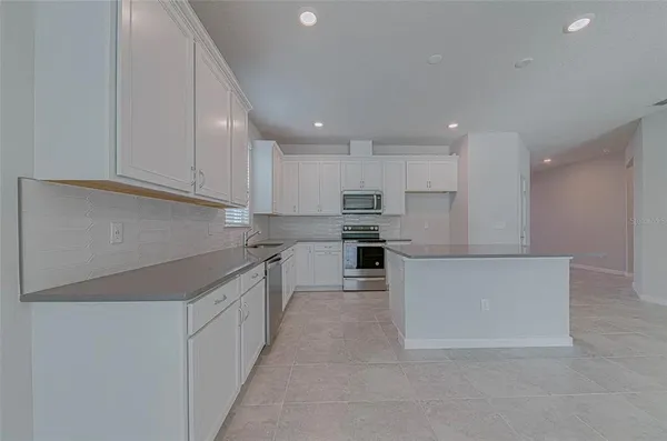 a kitchen with stainless steel appliances granite countertop a refrigerator sink and cabinets