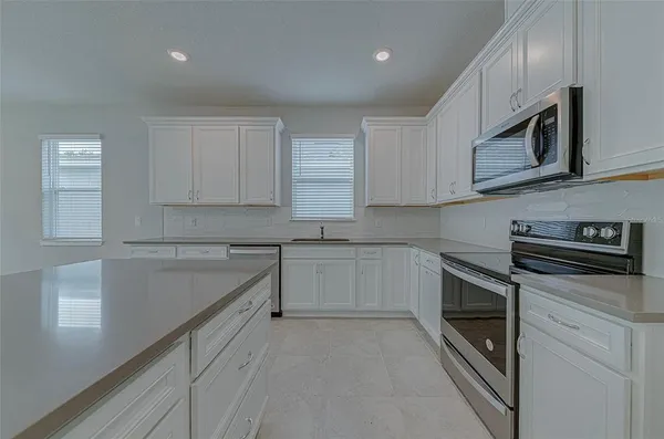 a kitchen with stainless steel appliances granite countertop a stove a sink and a microwave