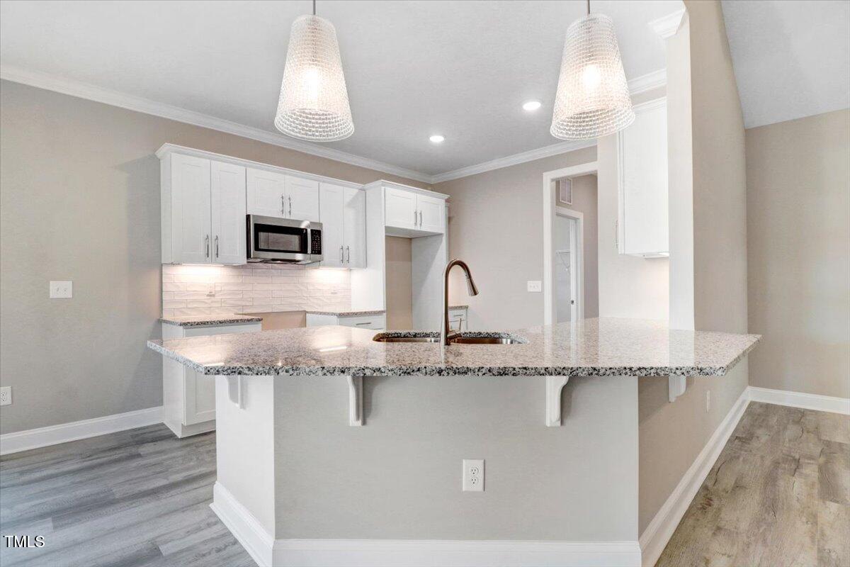 9550 Bear Run Lane Middlesex, NC 27557 - Photo 14 of 32 a kitchen with kitchen island granite countertop a sink a counter top space and cabinets