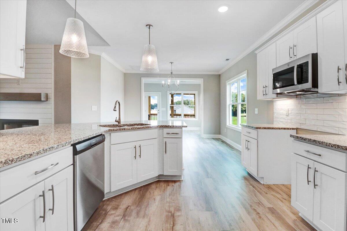9550 Bear Run Lane Middlesex, NC 27557 - Photo 18 of 32 a large kitchen with cabinets wooden floor and stainless steel appliances