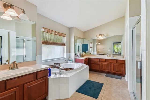 a large bathroom with a double vanity sink a mirror a bathtub and