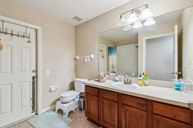 a bathroom with a double vanity sink mirror and toilet