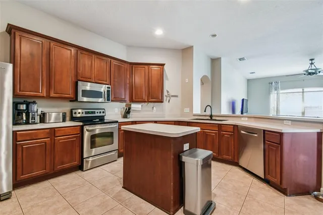 a kitchen with stainless steel appliances granite countertop wooden cabinets a sink and a stove