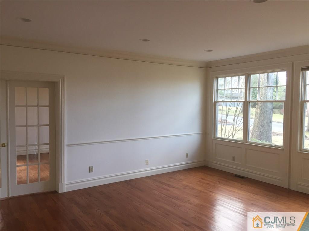 69 Athens Road Short Hills, NJ 07078 - Photo 4 of 25 an empty room with wooden floor and windows