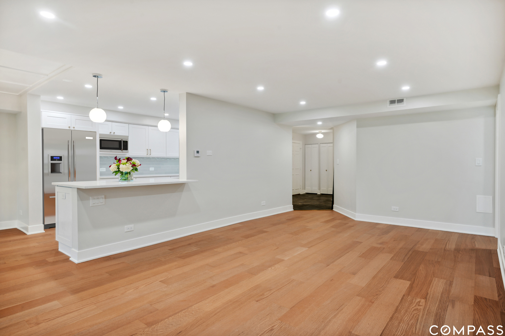 3801 Mission Hills Road, Unit 510 Northbrook, IL 60062 - Photo 7 of 21 a view of an empty room with kitchen view and wooden floor
