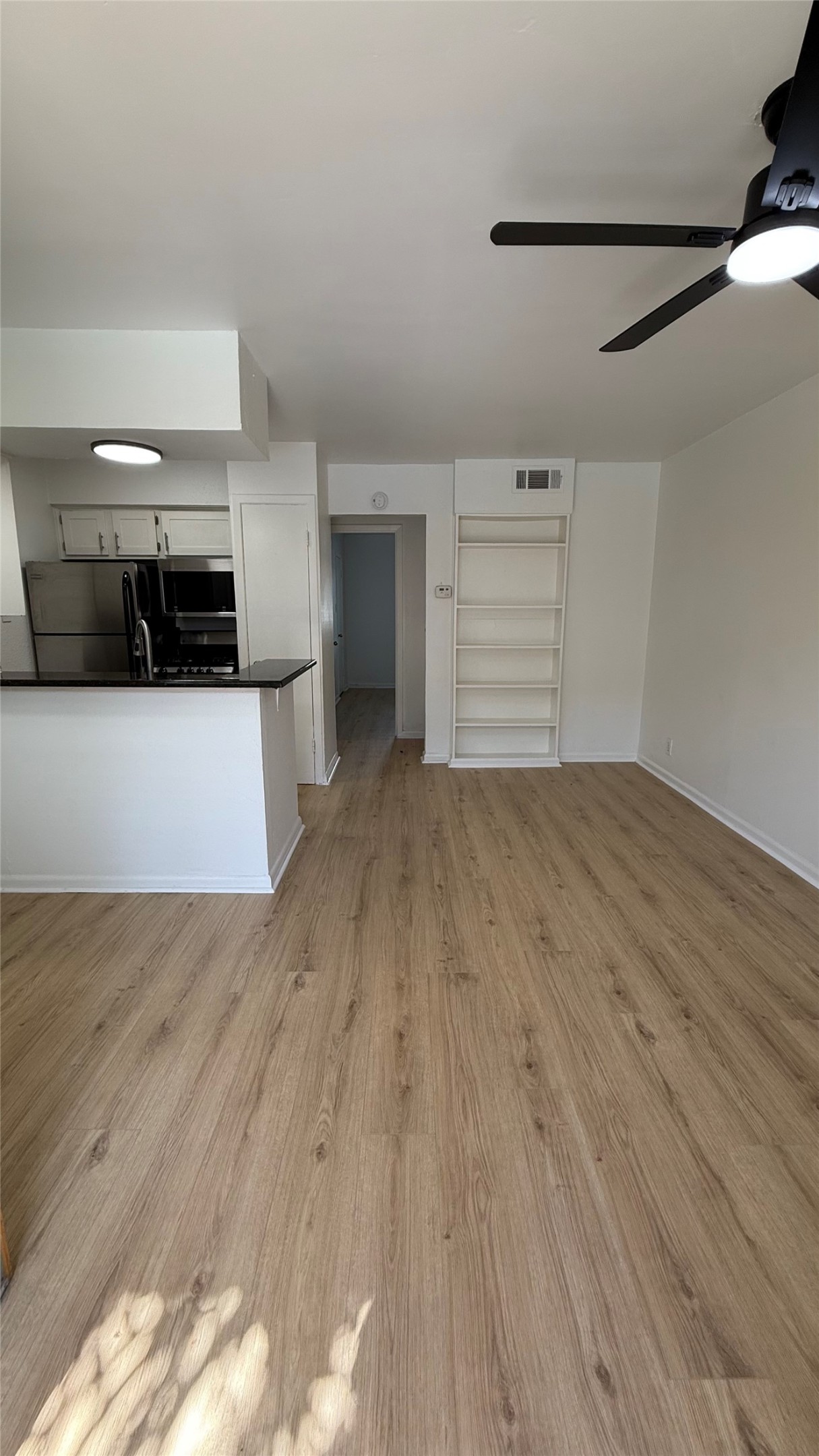 2401 Manor Road, Unit 126 Austin, TX 78722 - Photo 2 of 12 a view of a room with wooden floor and a ceiling fan