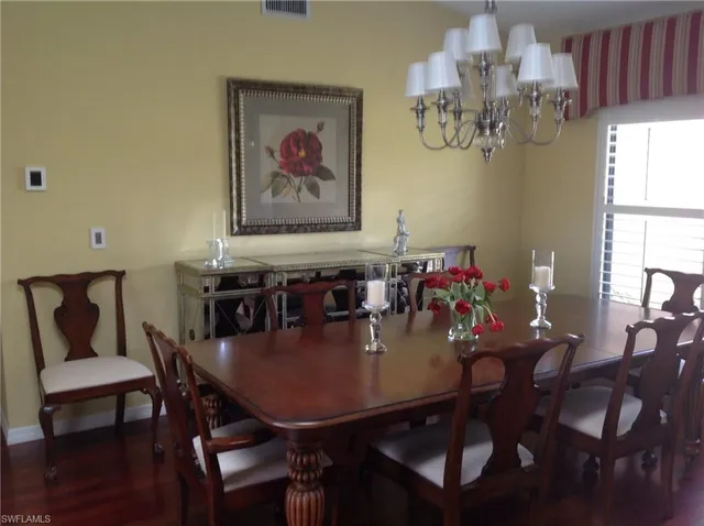 a view of a dining room with furniture a chandelier and wooden floor