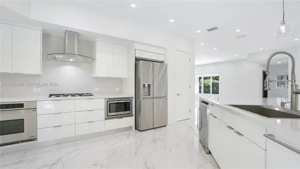 a kitchen with stainless steel appliances granite countertop a stove a sink and a refrigerator