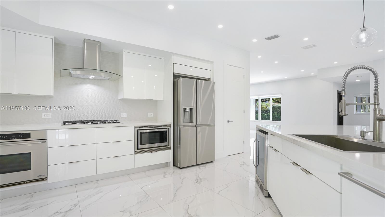 a kitchen with stainless steel appliances granite countertop a stove a sink and a refrigerator