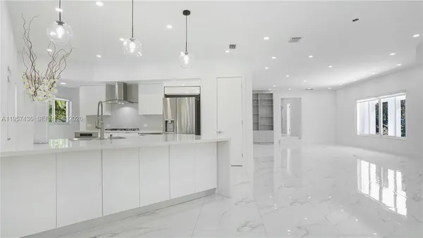 a large white kitchen with lots of counter space and a sink