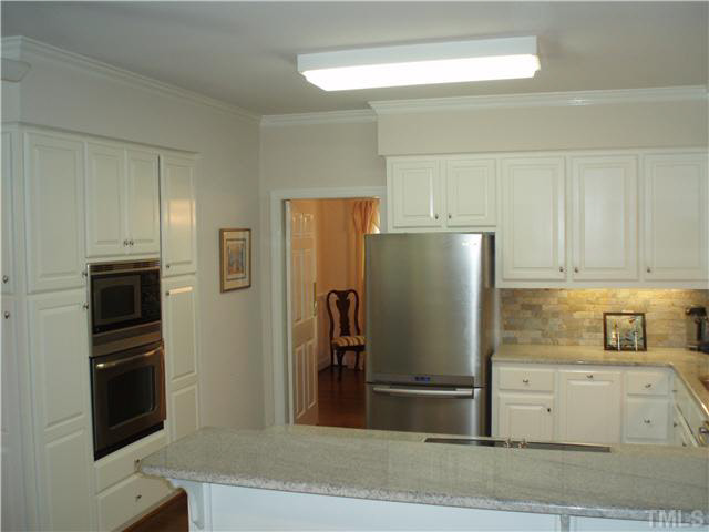 546 Dogeye Road Benson, NC 27504 - Photo 4 of 23 BRIGHT AND OPEN KITCHEN FEATURING STAINLESS APPLIANCES, GRANITE COUNTERTOPS, & TILE BACKSPLASH!