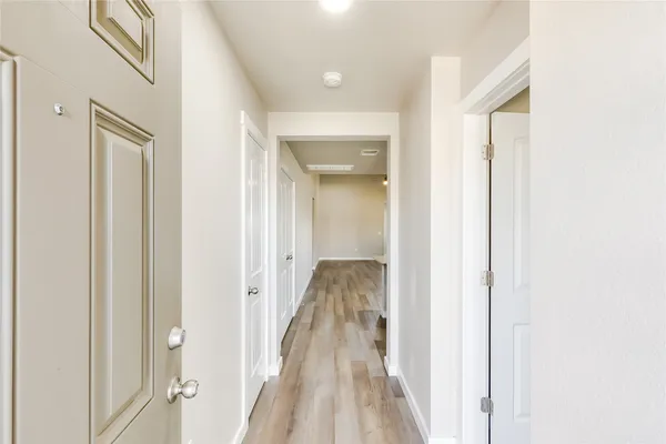 a view of a hallway with wooden floor and staircase