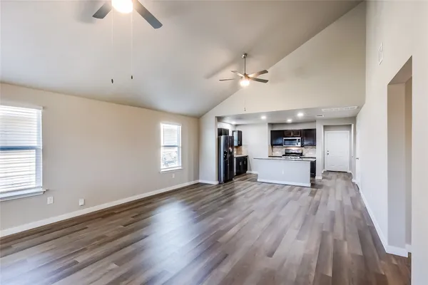 an empty room with wooden floor and mirror