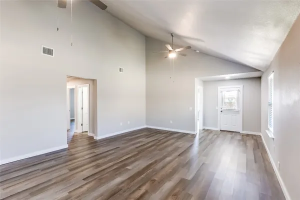 a large kitchen with stainless steel appliances kitchen island a large counter top and wooden floors