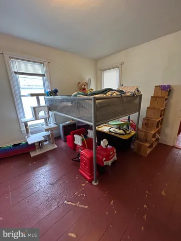 a bedroom with furniture and a wooden floor