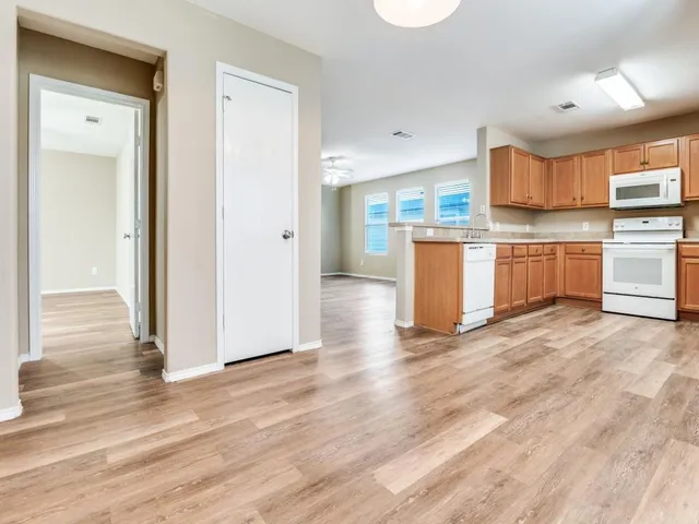 a kitchen with a refrigerator and wooden cabinets