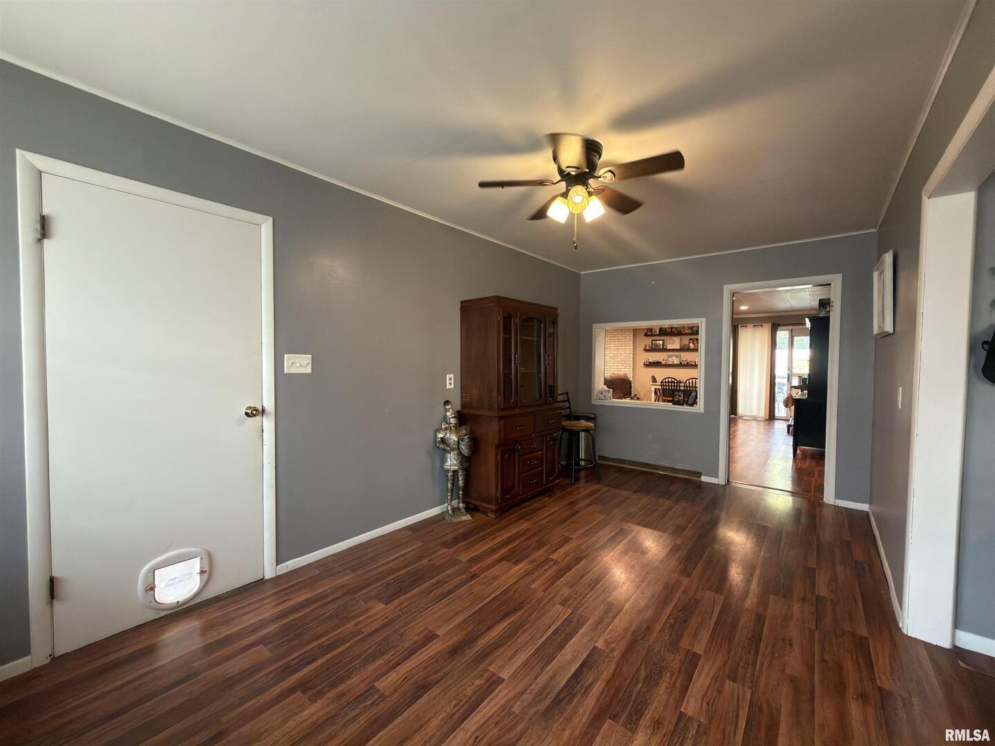 117 Marshall Place Carmi, IL 62821 - Photo 11 of 25 a view of a livingroom with a flat screen tv wooden floor and a ceiling fan