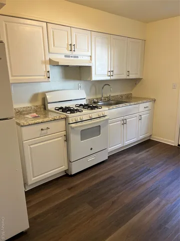 a white stove top oven sitting inside of a kitchen