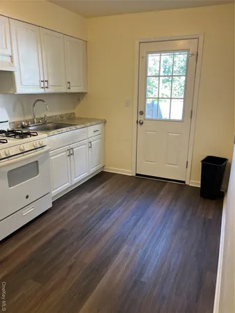 a view of a kitchen with wooden floor and electronic appliances