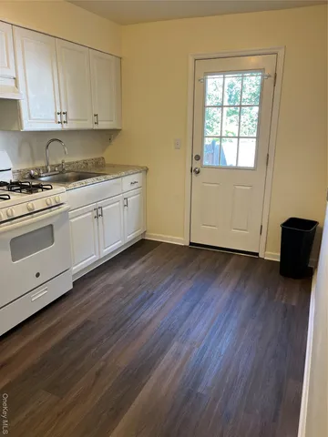a view of a kitchen with wooden floor and electronic appliances