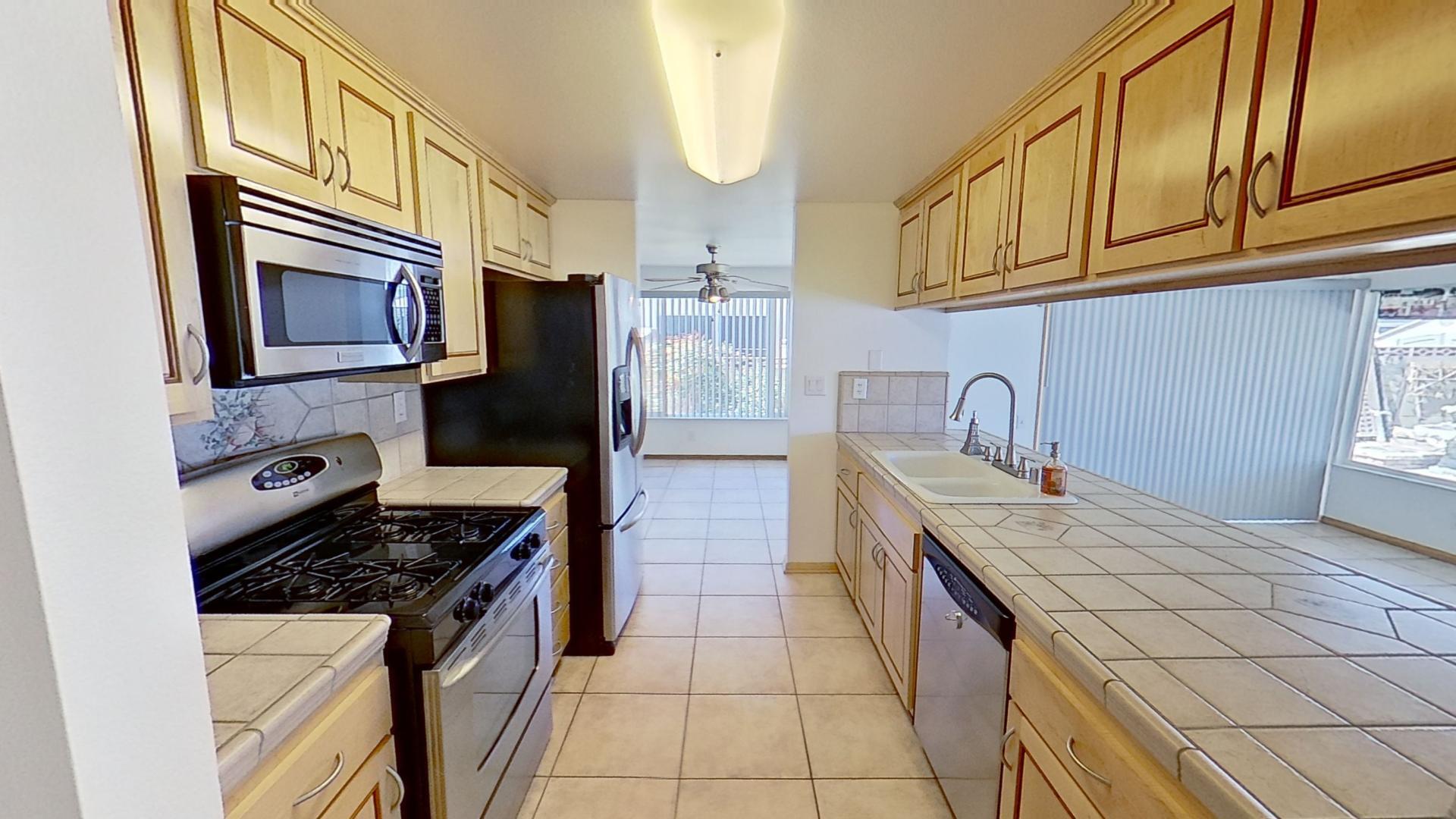 615 Eston Place Lancaster, CA 93535 - Photo 10 of 46 a kitchen with stainless steel appliances granite countertop a stove a sink and a microwave