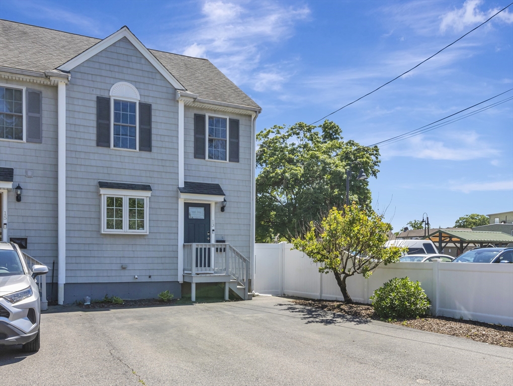 13 Shawmut Avenue, Unit 13 Mansfield, MA 02048 - Photo 2 of 34 a front view of a house with a yard and garage