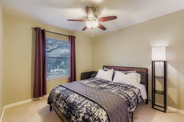 a bedroom with a large bed and a chandelier
