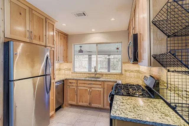 a kitchen with stainless steel appliances granite countertop a refrigerator sink and cabinets
