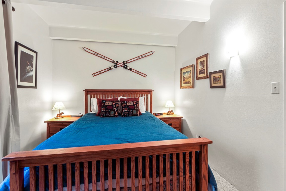 370 La Bonte Street, Unit F Dillon, CO 80435 - Photo 12 of 30 a bedroom with a bed and a chandelier