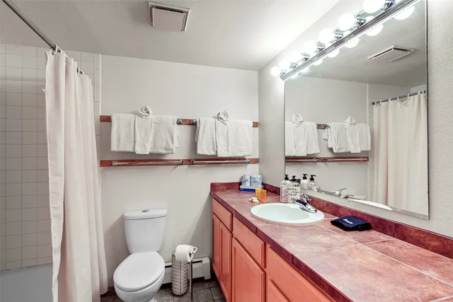 a bathroom with a granite countertop sink vanity mirror and shower