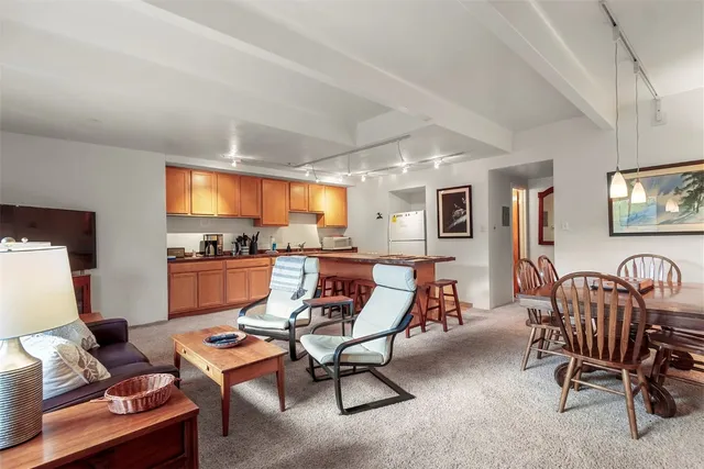 a living room with furniture kitchen view and a window