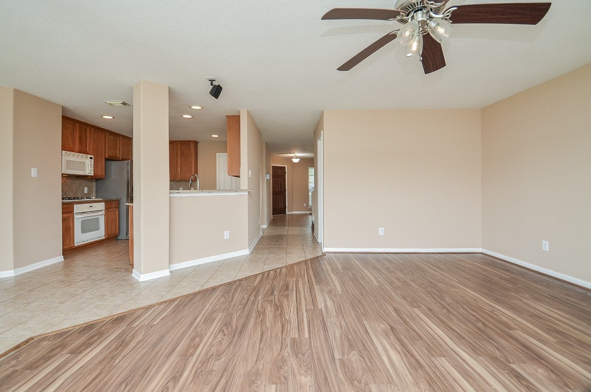 7134 Winston Ranch Parkway Richmond, TX 77406 - Photo 10 of 32 a view of a kitchen with a fridge and wooden floor