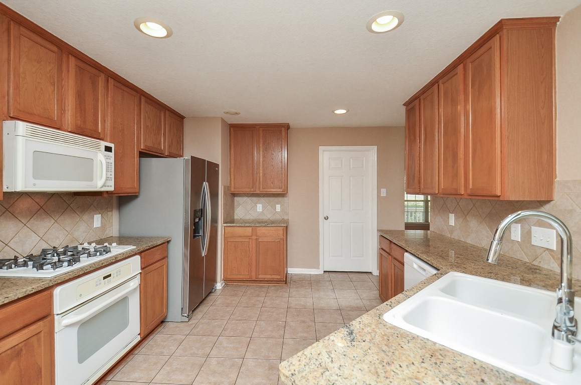 7134 Winston Ranch Parkway Richmond, TX 77406 - Photo 13 of 32 a kitchen with a refrigerator and a sink